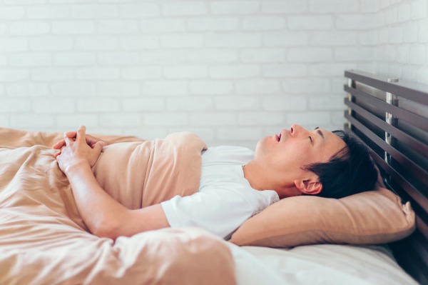 口を開けて口呼吸で眠る男性｜姿勢と噛み合わせや歯並びの意外な関係